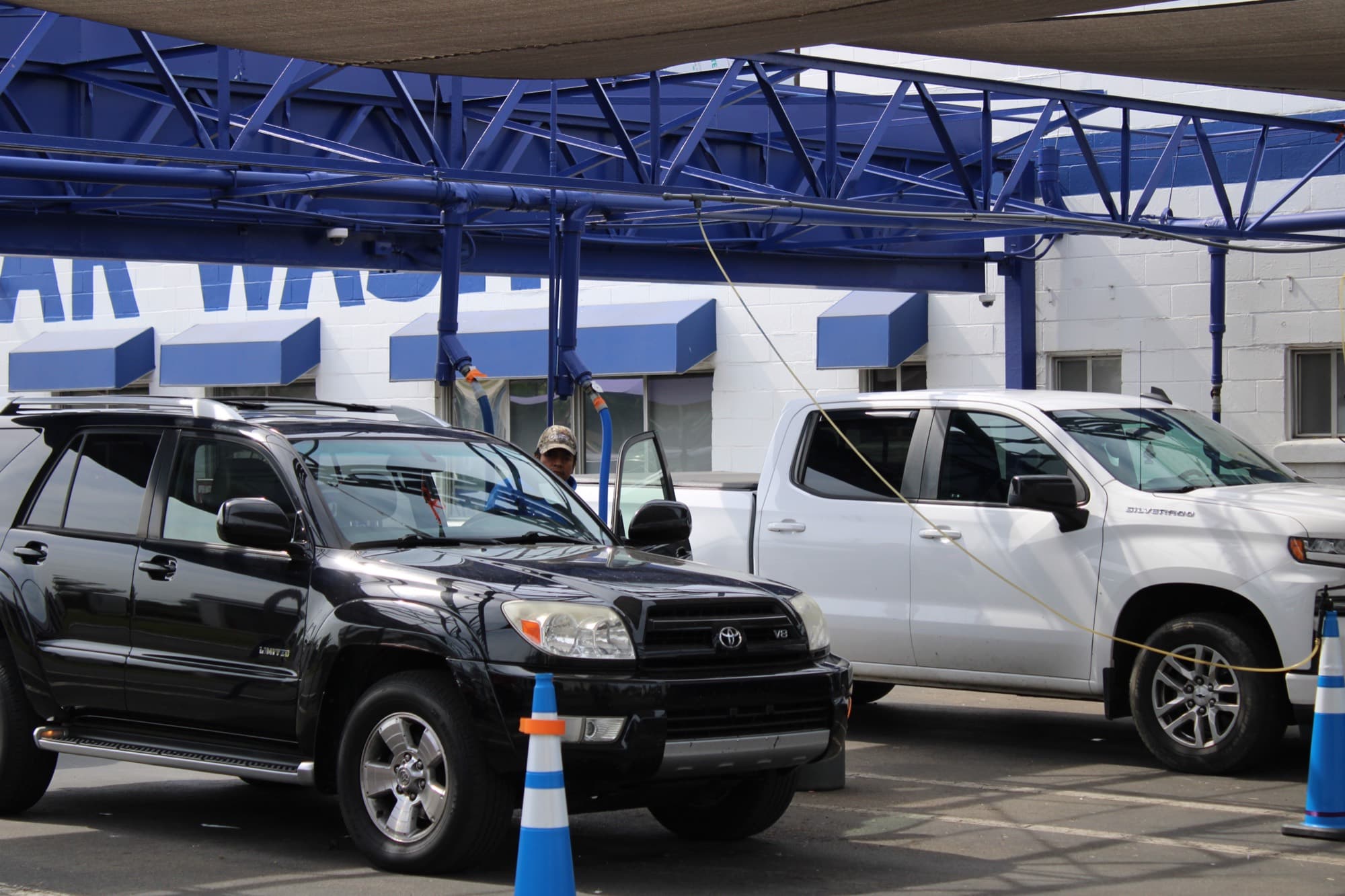 Vehicles lined up for hand-prep under the canopy at Jeff's Car Wash